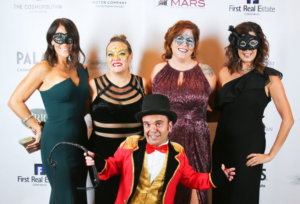Image of a group of women and a man in costume at a Las Vegas law firm's masquerade event, suitable for personal injury legal representation.