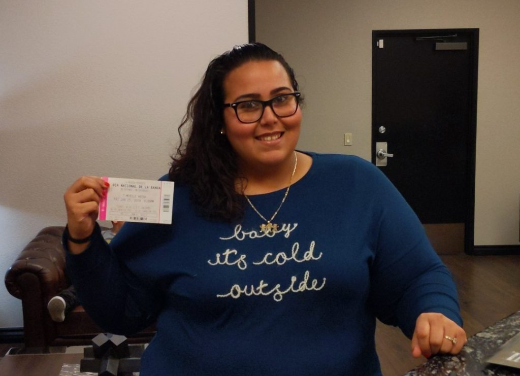 A smiling woman in glasses holds a ticket, representing the firm's commitment to its clients and their well-being in Las Vegas personal injury cases.