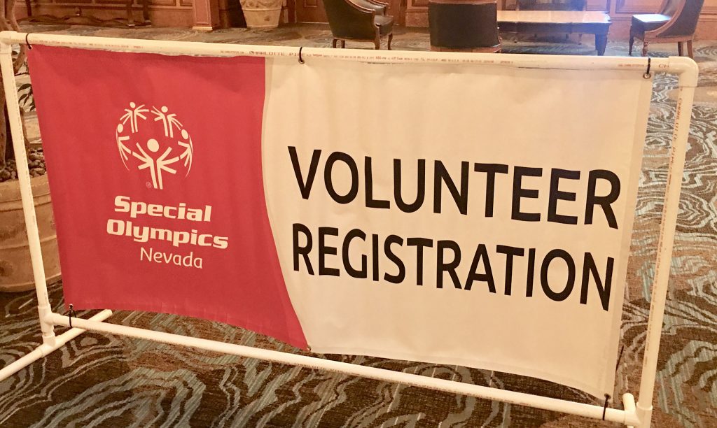 Close-up of a Special Olympics Nevada volunteer registration banner, symbolizing community involvement and the Las Vegas values of supporting those who may be vulnerable, reflecting the compassion of a dedicated personal injury law firm.