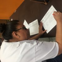 Woman signing Three Square welcome sheet