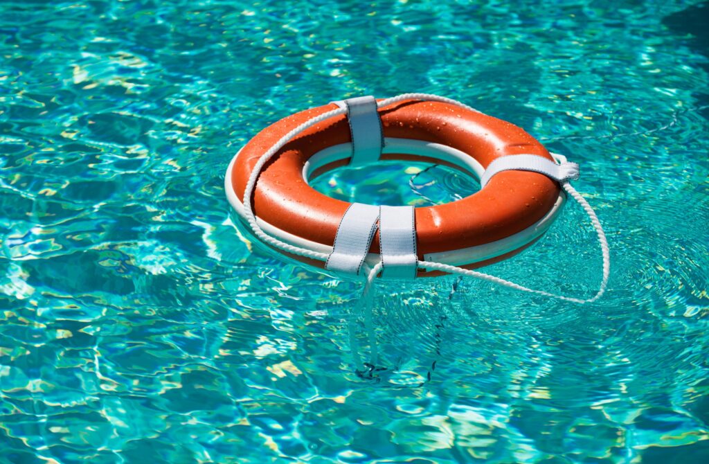 Orange life preserver floating on a turquoise pool surface, representing water safety and potential legal support for pool accidents and personal injury claims in Las Vegas.