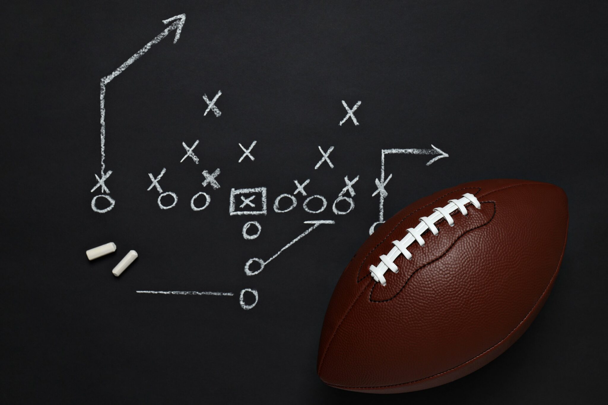 Football on a chalkboard with a play drawn in chalk, symbolizing strategy for personal injury cases in Las Vegas.