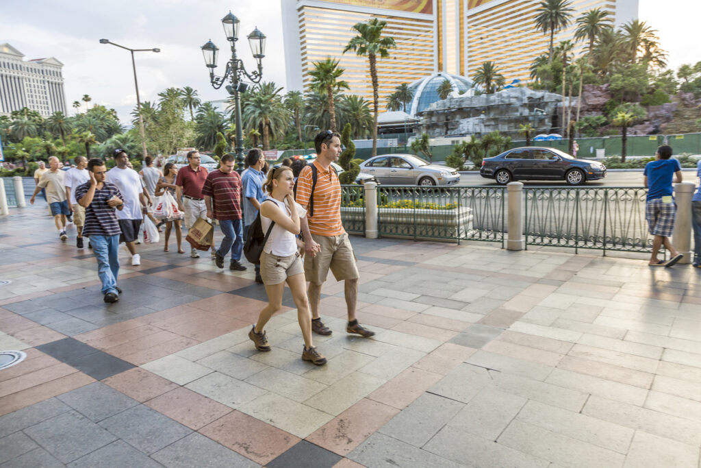 Understanding Pedestrian Accidents in Las Vegas: Causes and Prevention 3 Crowded sidewalk scene in Las Vegas, highlighting pedestrian traffic near a busy street with cars, representing potential risks and need for personal injury lawyers.