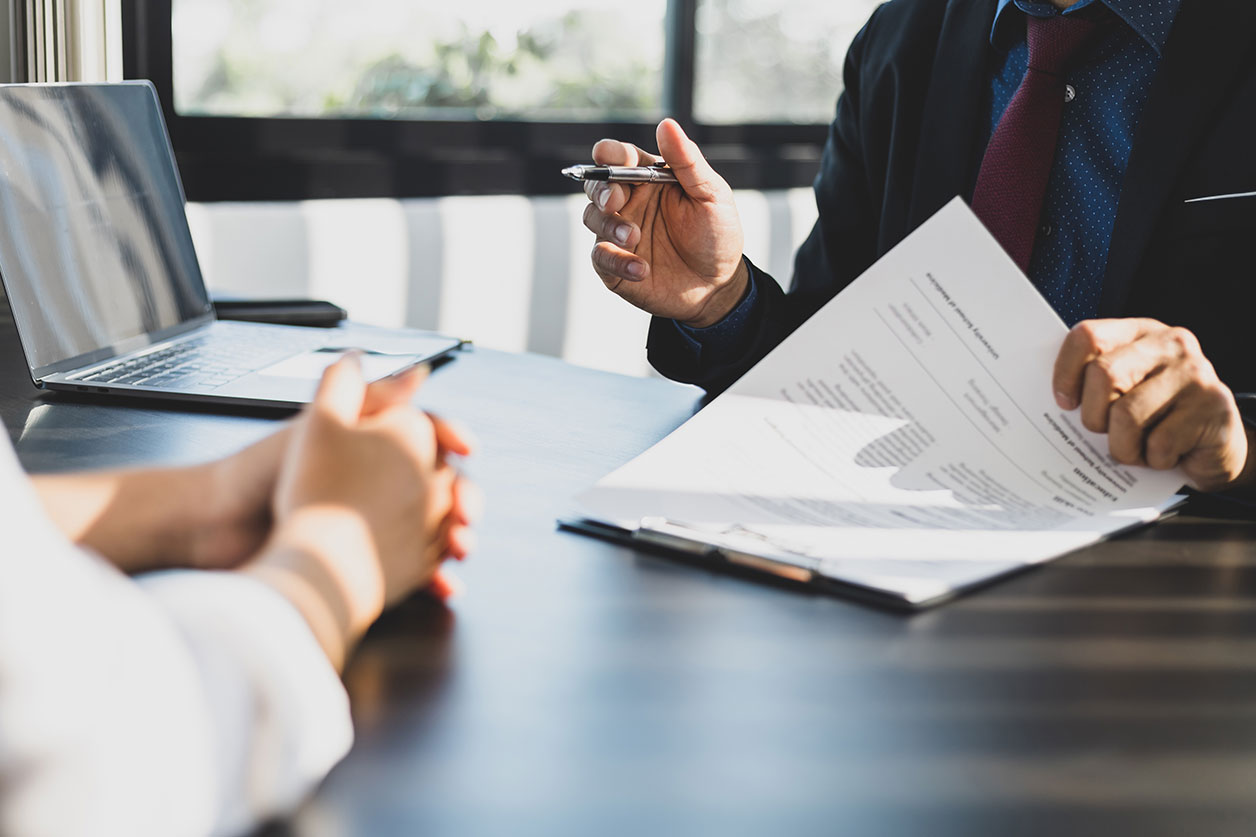 Close-up shot of a client meeting with a lawyer in Las Vegas, discussing paperwork related to a personal injury claim, with a laptop in the background.