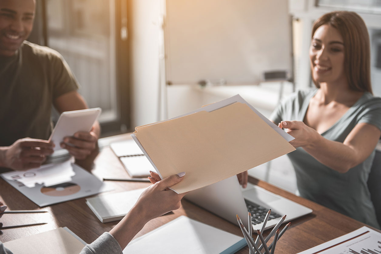 A diverse team at a Las Vegas personal injury law firm reviews case files and data analytics on tablets and laptops, collaborating to build strong cases for their clients.