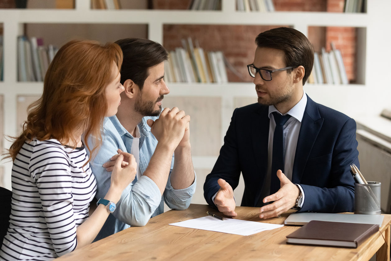 A young couple consults with a Las Vegas Personal Injury Lawyer in a modern office setting, discussing their case and legal options after an accident.