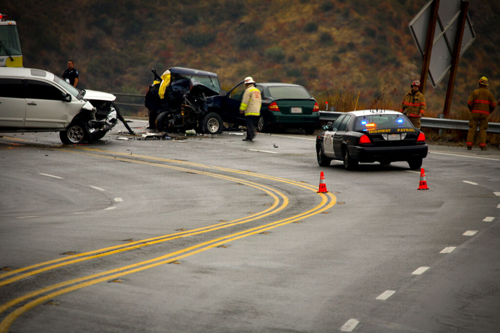 Scene of a multi-vehicle car crash on a winding road with police and emergency personnel present, suitable for representing personal injury cases in Las Vegas.