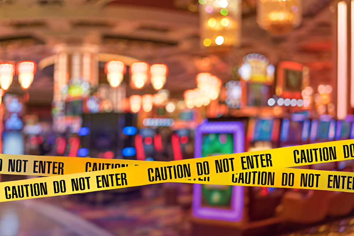 Blurred image of a Las Vegas casino interior cordoned off with yellow caution tape reading "Caution Do Not Enter," indicating a possible accident site requiring personal injury legal assistance.